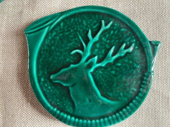 Dessous de bouteilles  faïence verte à décor de cerfs.