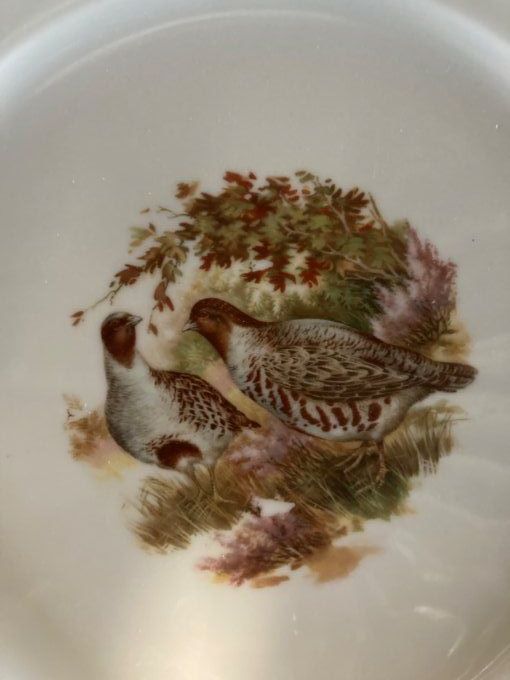 2 assiettes plates à décor de bécasses et perdreaux.