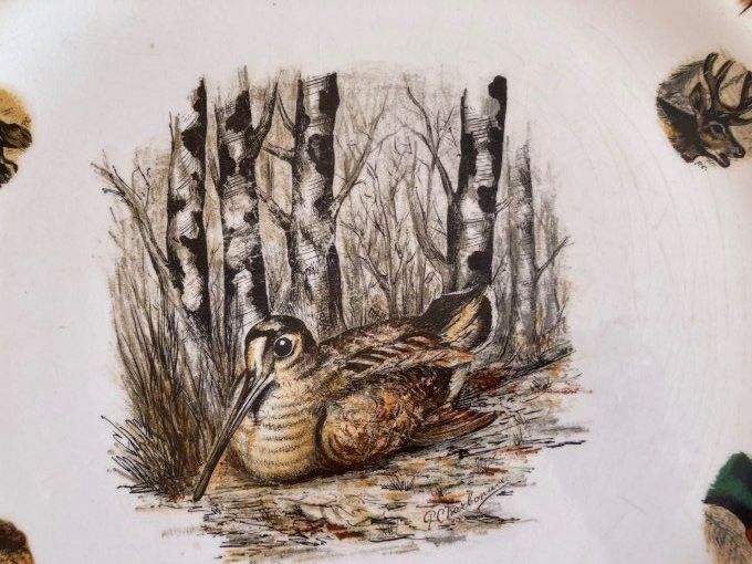 Plat rond à décor de gibiers, becasse au centre  Limcolor