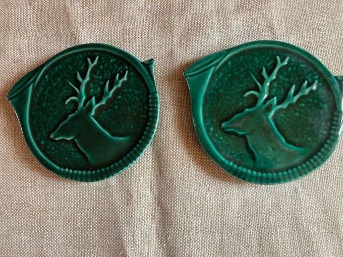 Dessous de bouteilles  faïence verte à décor de cerfs.